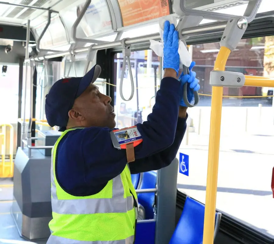 foto de um homem limpando uma frota de ônibus